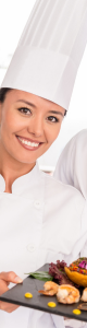 Female chef smiling in a chef jacket and chef hat